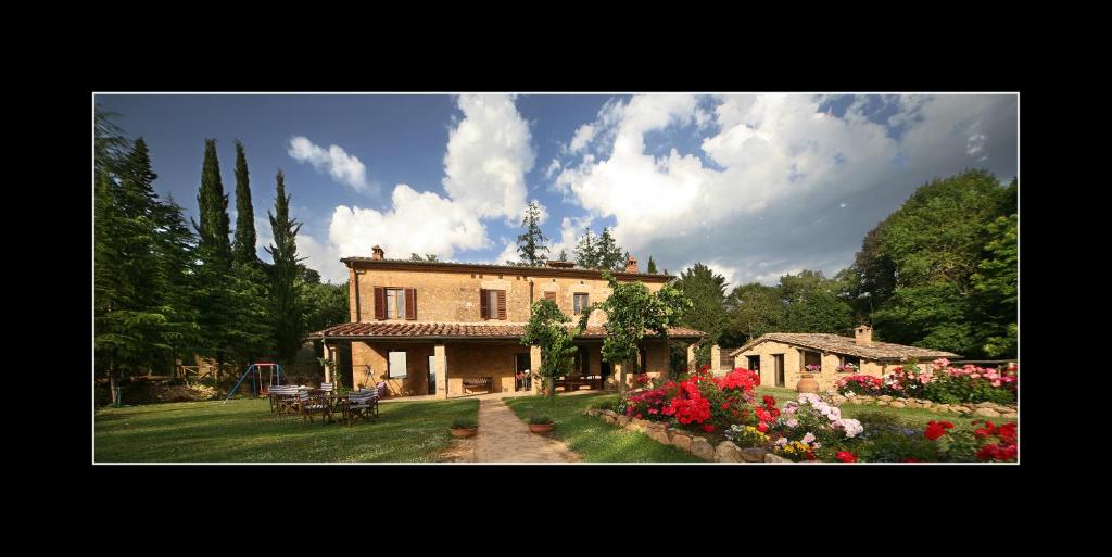 a large house with flowers in a yard at Podere Marroneto in Lama
