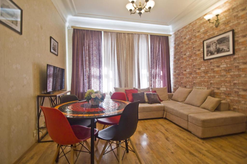 a living room with a couch and a table at LAFLATS Volkhonka in Moscow