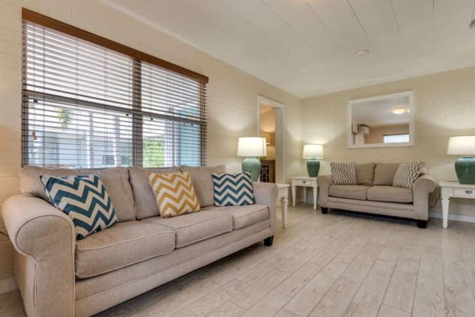 a living room with a couch and a chair and a table at Mulberry Cottage in Siesta Key