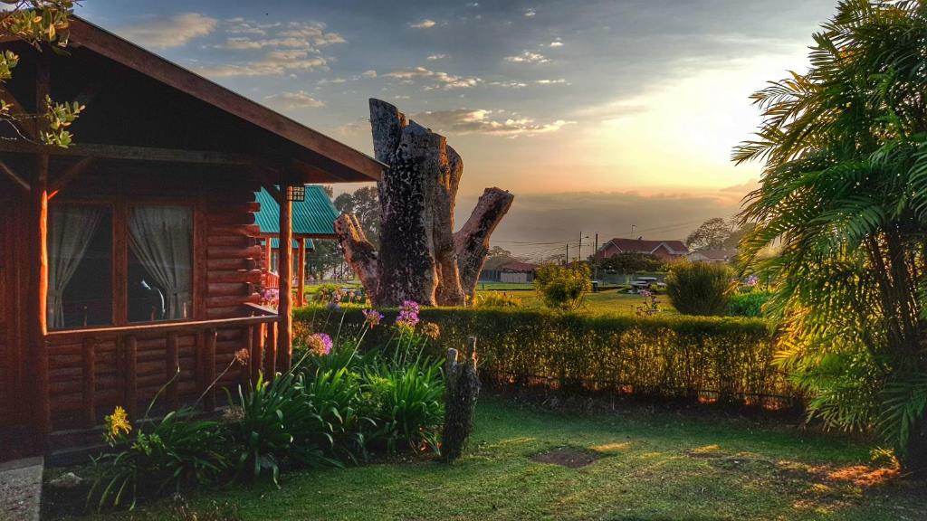 ein Haus mit einem Baum neben einem Zaun in der Unterkunft Grandpas Hotel & Restaurante in Cartago
