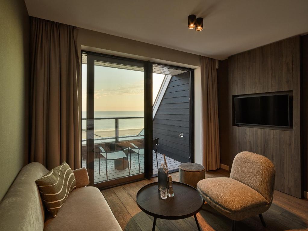un salon avec vue sur l'océan dans l'établissement Hotel de Blanke Top, à Cadzand-Bad