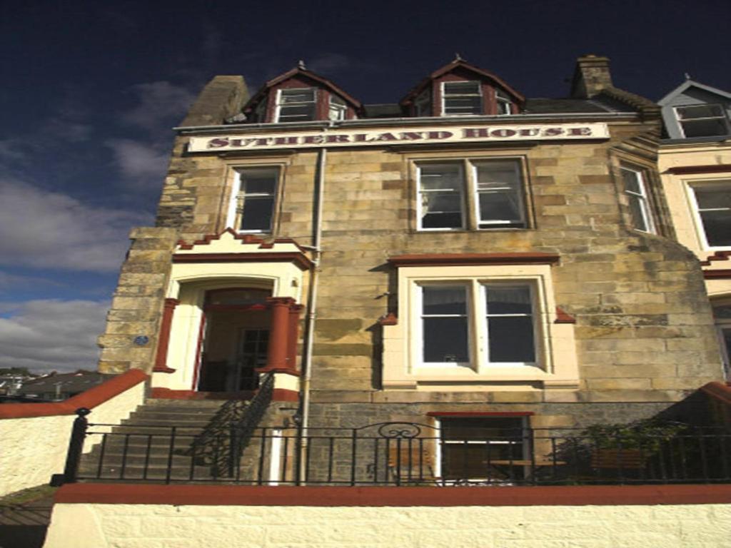 um edifício com uma placa na frente dele em Sutherland House em Oban