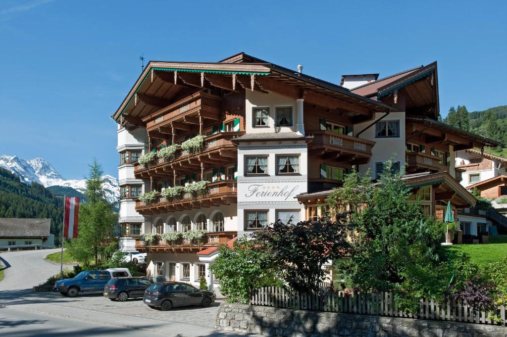 un edificio con auto parcheggiate di fronte di Hotel-Appartement Ferienhof a Gerlos