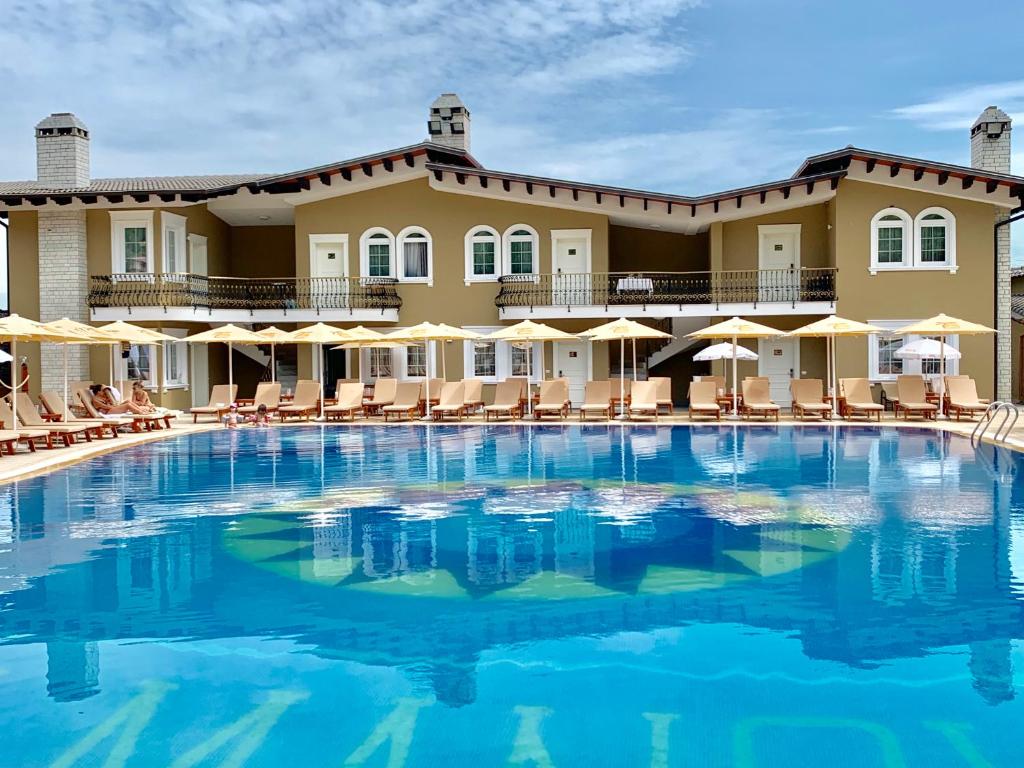 a large swimming pool in front of a hotel at PalmaNova Resort in Tirana