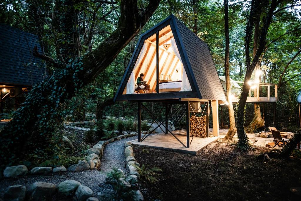 a person sitting in a tiny house in the woods at Duende Hotel in Lagodekhi