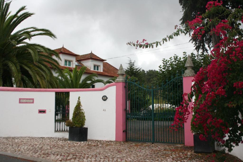 a pink and white house with a gate and flowers at Quinta De Sao Francisco in Sintra