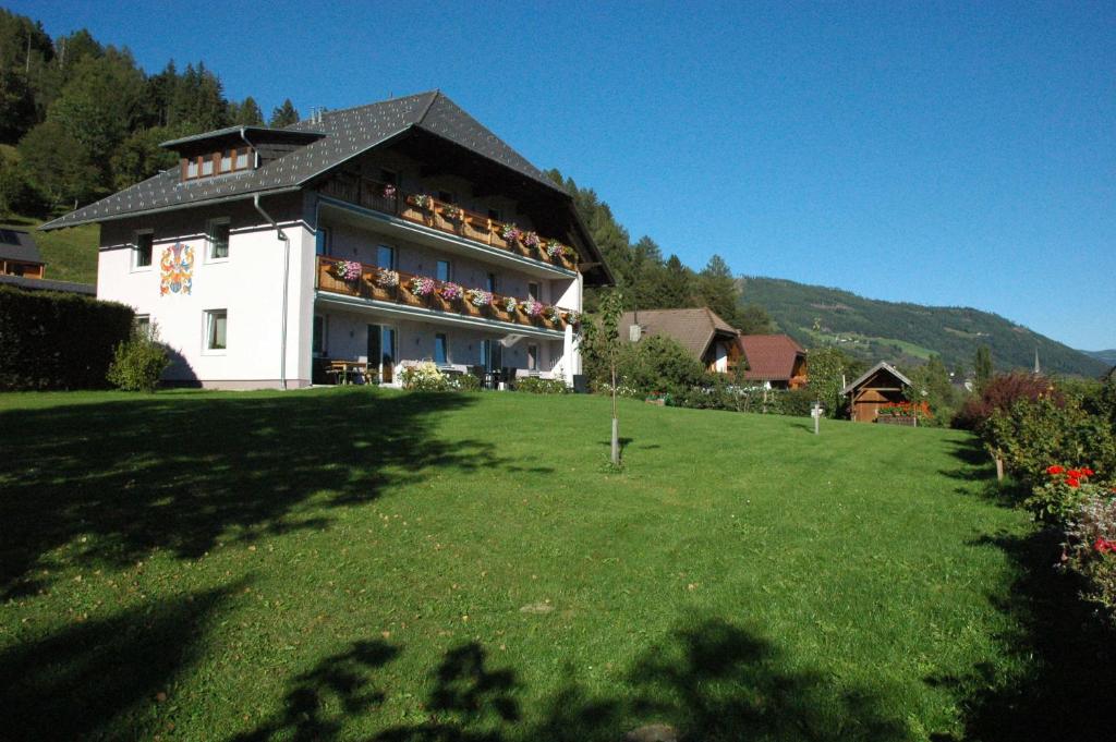 a large building with balconies on the side of a lawn at Appartement Haus Moser in Sankt Michael im Lungau