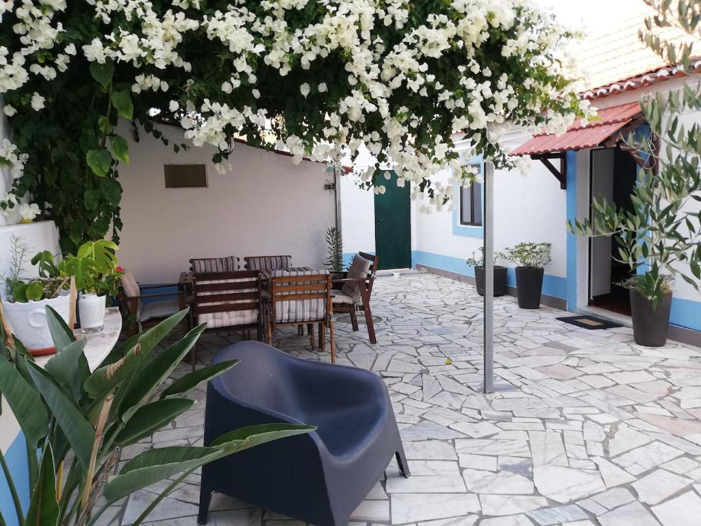 a patio with a table and chairs and flowers at Casa Ferry Trafaria in Trafaria