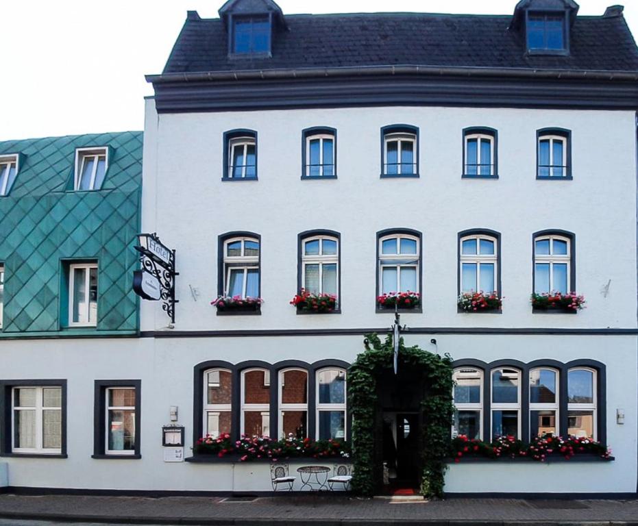 ein weißes Gebäude mit Fenstern und Blumen darauf in der Unterkunft Hotel Landhaus zur Issel in Isselburg