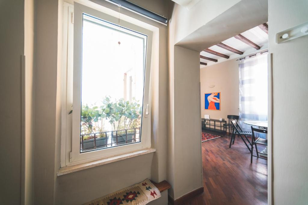 un couloir avec une grande fenêtre et une salle à manger dans l'établissement Beautiful apartament 2 minute walk from Colosseum, à Rome