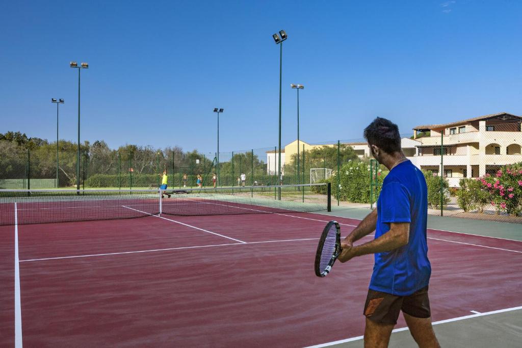 a man holding a tennis racket on a tennis court at Hotel Abi d'Oru in Porto Rotondo