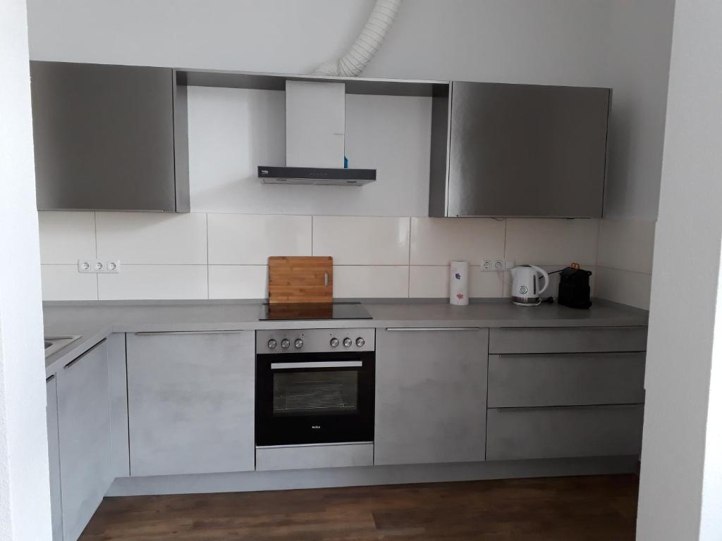 a kitchen with white cabinets and an oven at Ferienwohnung Ela in Wilhelmshaven