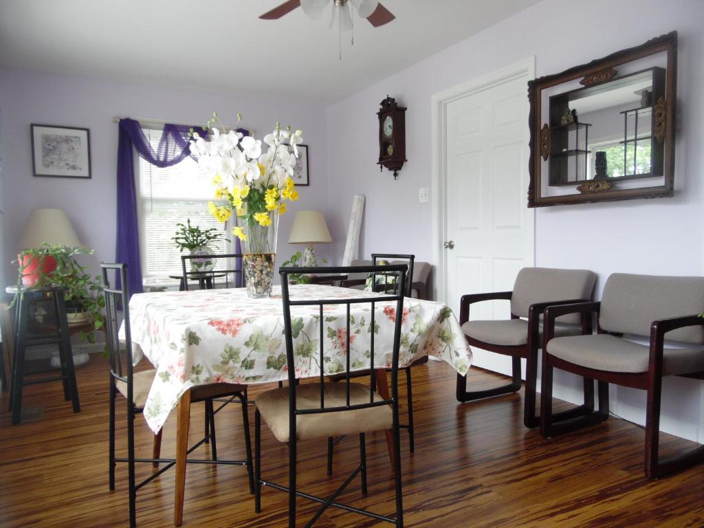 un comedor con una mesa con un jarrón de flores en Cantuta Inn en Harpers Ferry