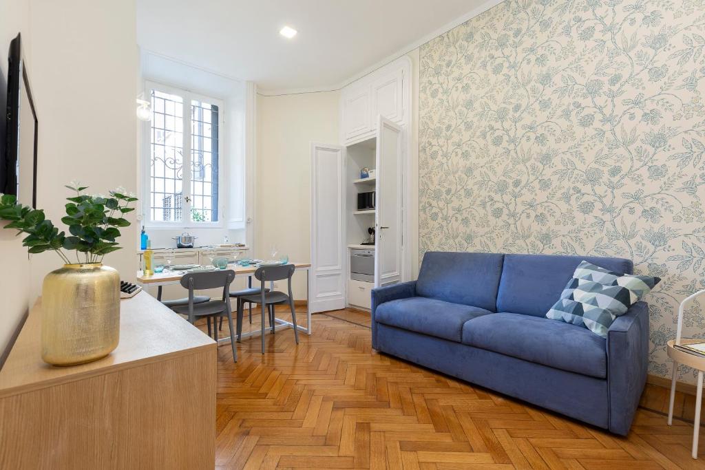 a living room with a blue couch and a table at ViaBoschetti1 in Milan