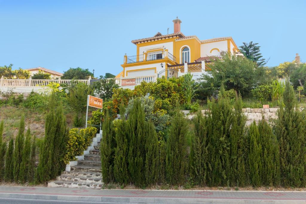 una casa al lado de una carretera con plantas en Alojamiento Colina del Sol, en Torrox