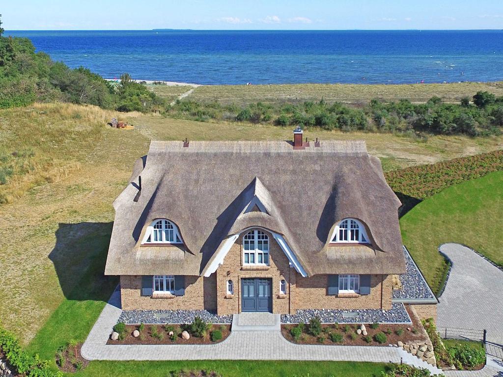 an aerial view of a house with the ocean in the background at Strandhaus 7 "Ostsee" F663 mit Meerblick, Sauna, Kamin in Lobbe