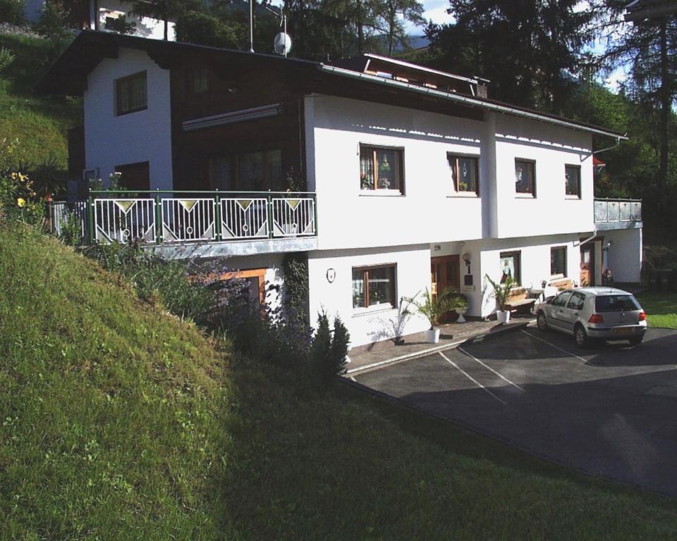 a white house with a car parked in front of it at Appartements Falkner in Roppen