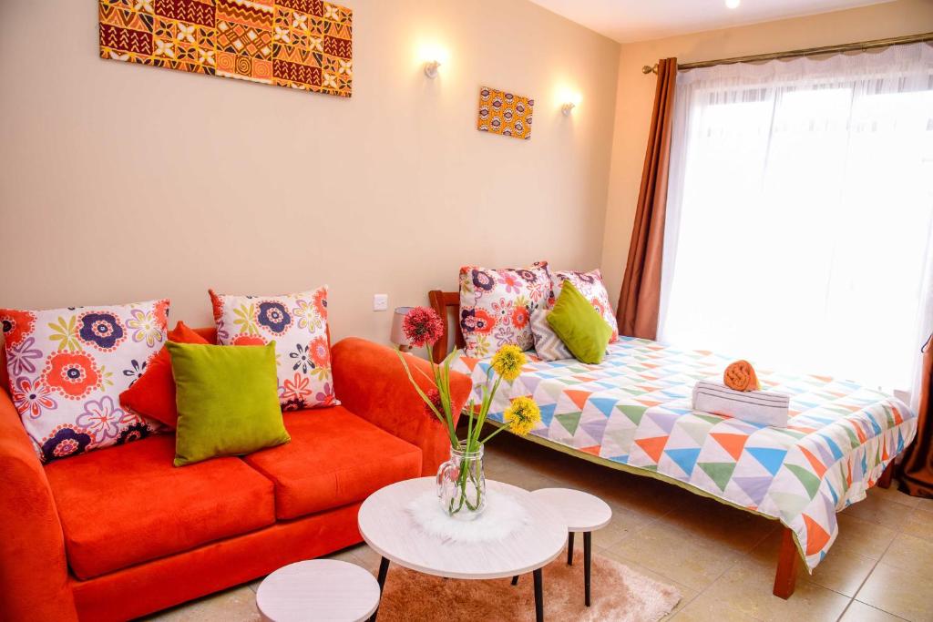 a living room with a couch and a table at PIT-STOP NAIROBI: LOCATED NEAR AIRPORT & TOURIST CIRCUIT in Nairobi