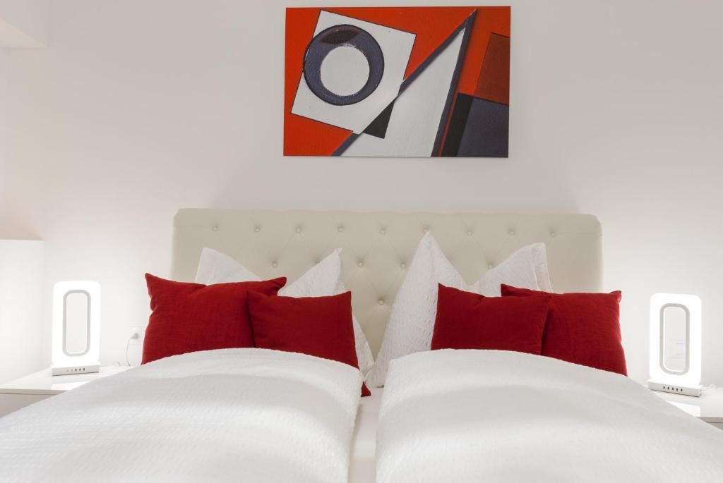 1 dormitorio con cama blanca y almohadas rojas en Apartment Hanni, en Merano