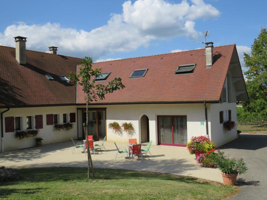 a house with a table and chairs in the yard at Les chambres du cru in Jongieux