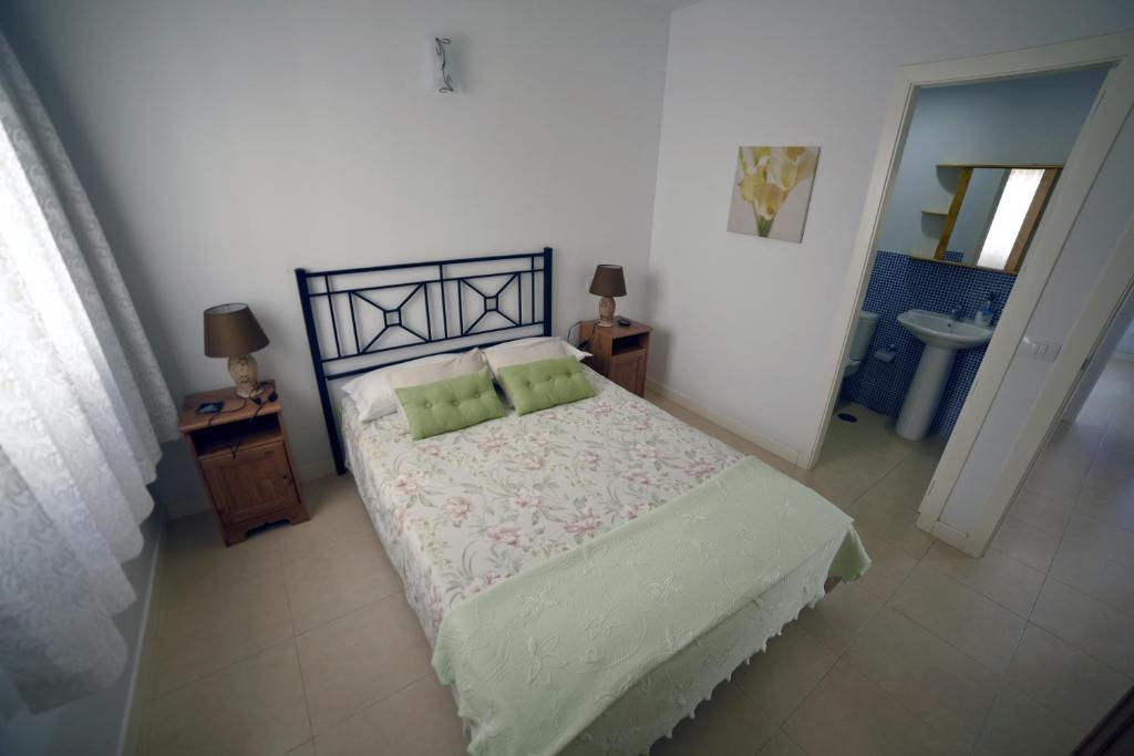 a bedroom with a bed with two green pillows at Casa Lola in Agaete