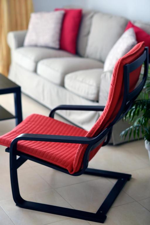 a red chair in a living room with a couch at Casa Lola in Agaete