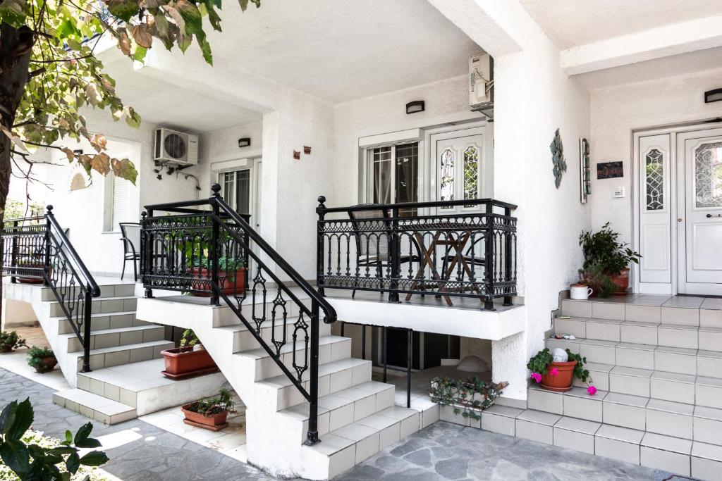 una casa bianca con scale e piante in vaso di Anthos Apartments a Limenas