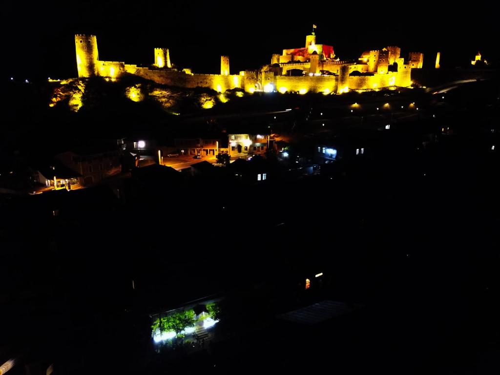 duży zamek jest oświetlony w nocy w obiekcie Host Family w Achalciche