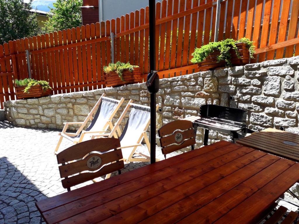 twee stoelen en een tafel en een piano op een patio bij Apartament Grota in Szklarska Poręba