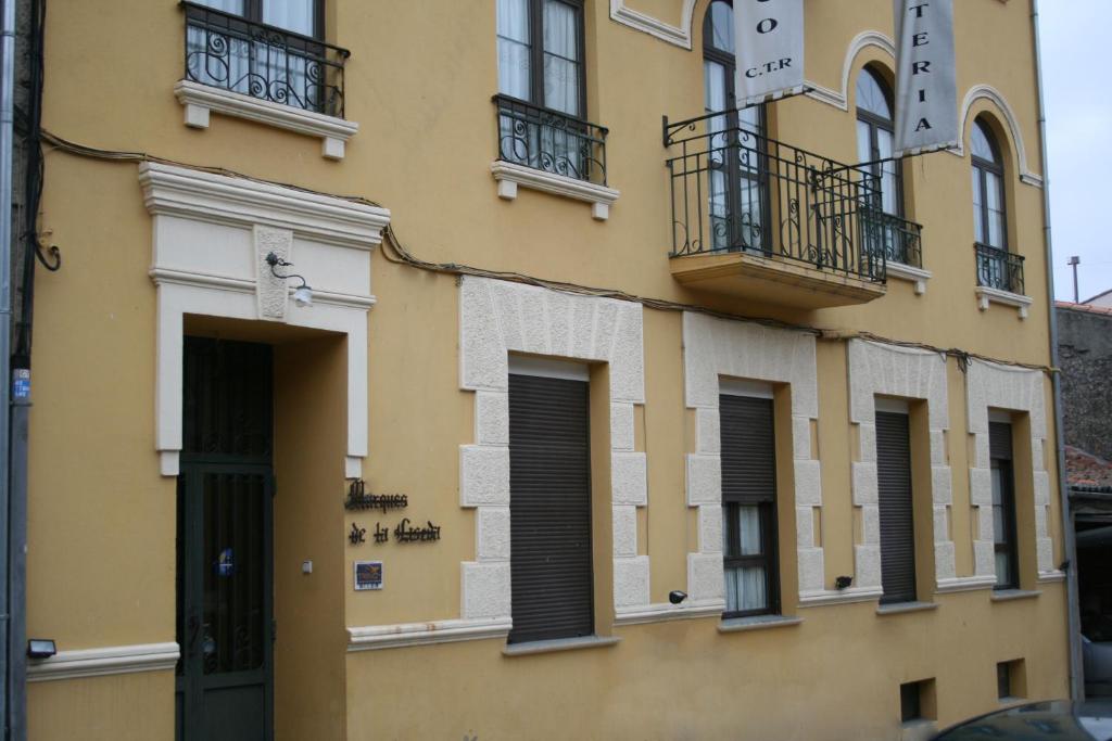 un edificio amarillo con ventanas y balcones. en Hotel Rural La Enoteca del Marques, en Fermoselle