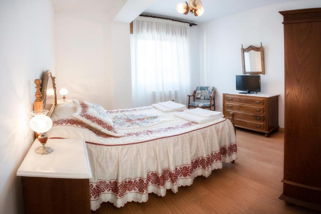 een slaapkamer met een bed, een dressoir en een spiegel bij HOTELBARCELONA in Entrimo