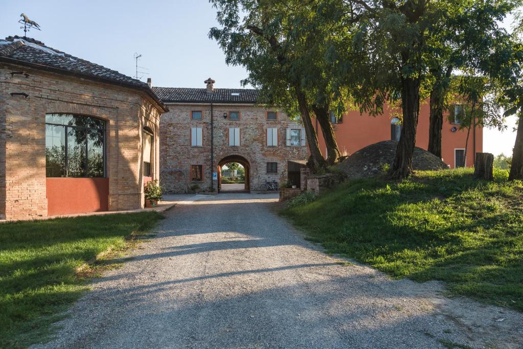 a road leading to a large brick building at Agriturismo Battibue in Fiorenzuola dʼArda