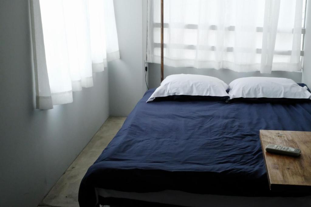 a bed with two pillows and a table in a room at Beppu hostel&cafe ourschestra - Vacation STAY 45859 in Beppu