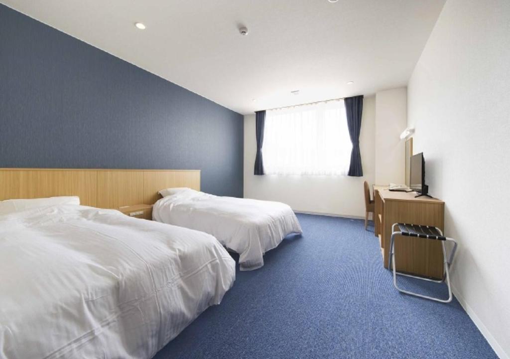 a hotel room with two beds and a television at Higashimatsushima - Hotel / Vacation STAY 43094 in Higashimatsushima