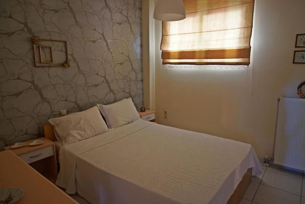 sypialnia z białym łóżkiem i oknem w obiekcie Christinas garden w mieście Patras