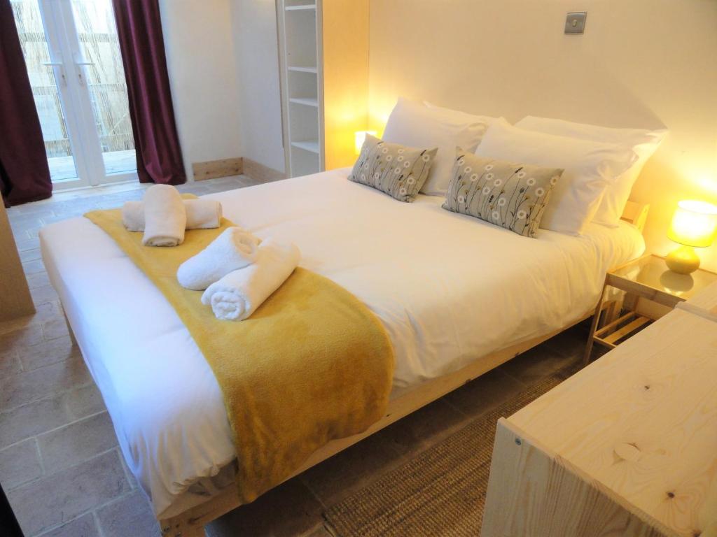 a bedroom with a large white bed with towels on it at The Little Luckwell Apartment by Cliftonvalley Apartments in Bristol