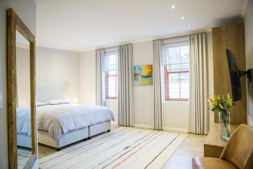 1 dormitorio con 1 cama y un jarrón de flores en Stunning House in Bo Kaap en Ciudad del Cabo