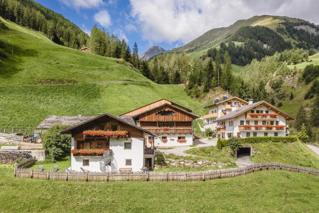 a group of buildings on a grassy hill at Reden Hof in Selva dei Molini