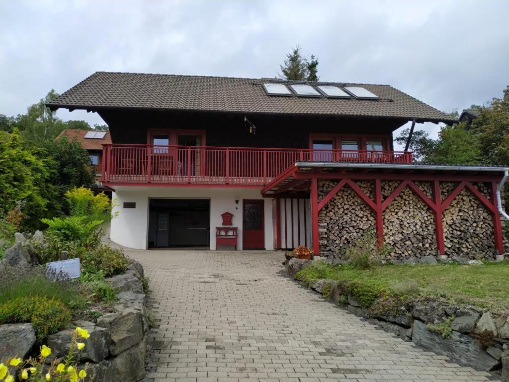 a red and white house with a red balcony at Ferienhaus Winterberg in Bromskirchen