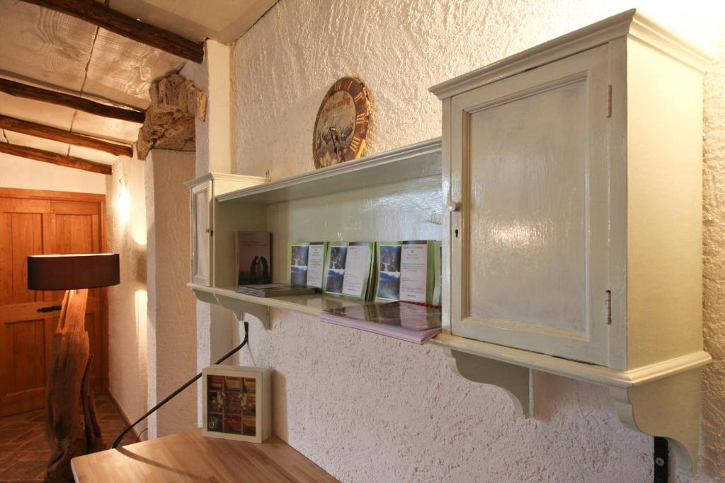 un armadietto bianco su un muro con mensola di Agriturismo Crotto Di Somana a Mandello del Lario