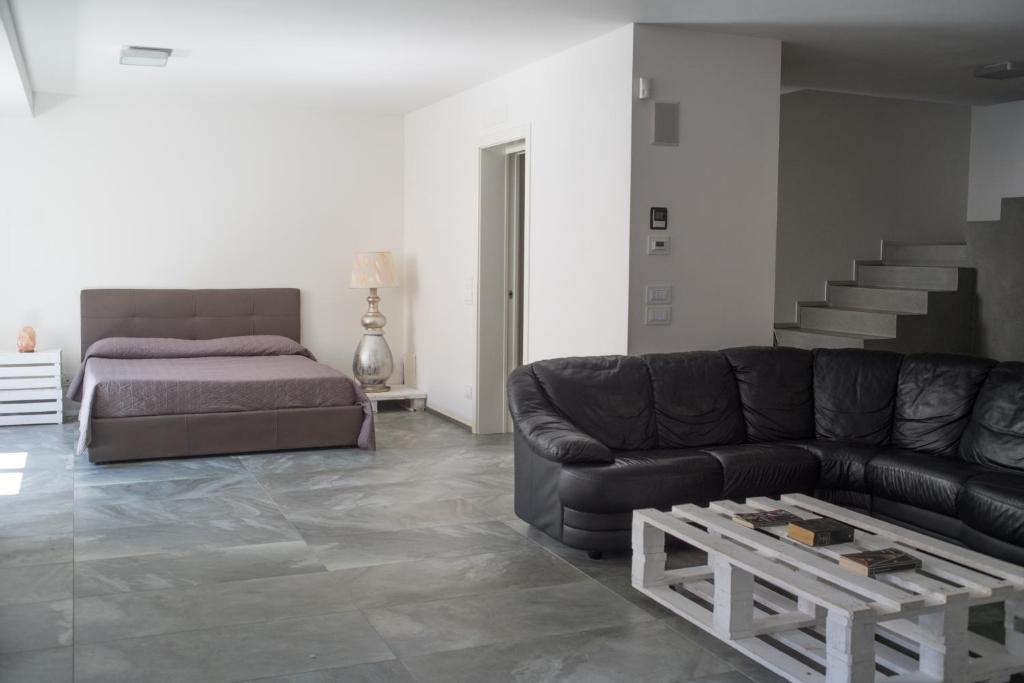 - un salon avec un canapé et un lit dans l'établissement Relais Officina del Tempo, à Paese