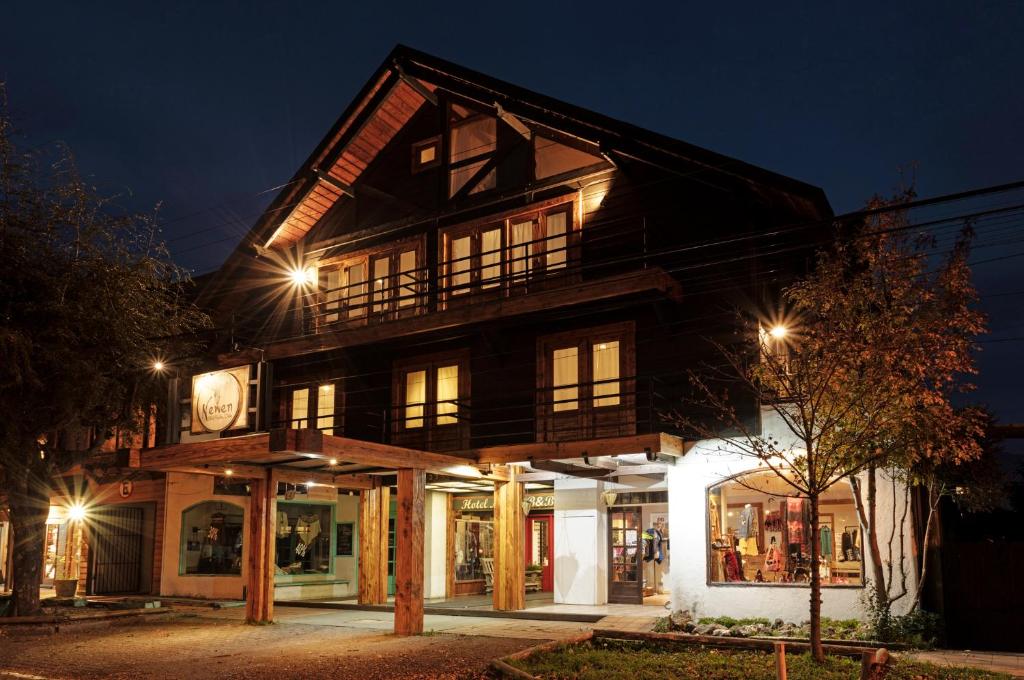 un gran edificio de madera con reloj por la noche en Newen B&B, en Pucón