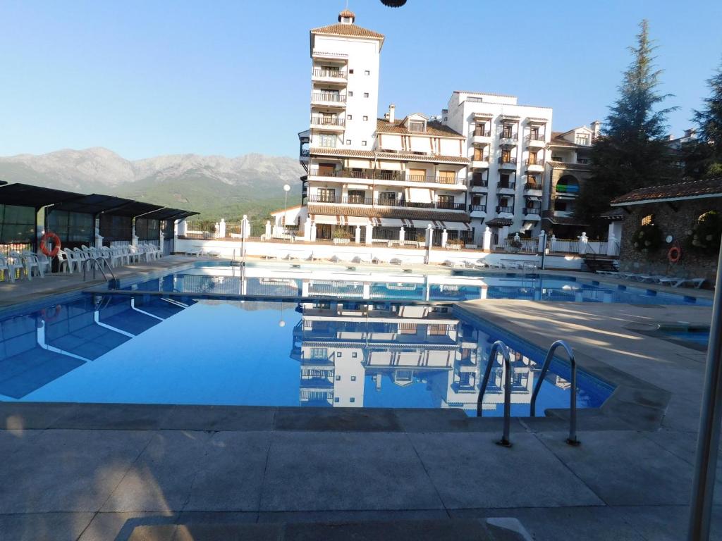 a large swimming pool in front of a building at El pequeño capricho in Arenas de San Pedro