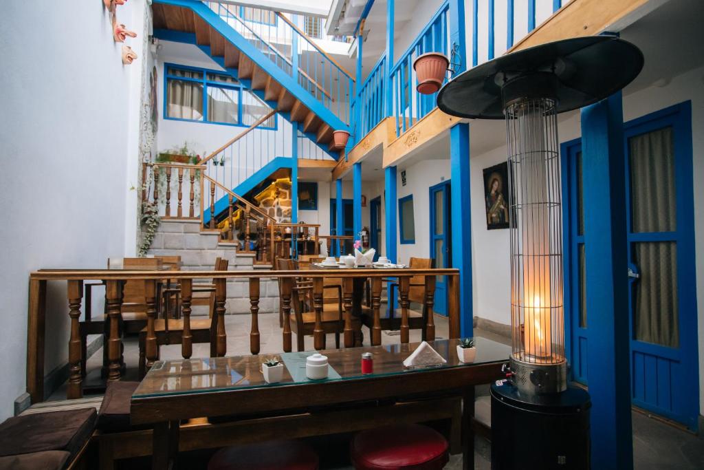 un restaurante con mesas y sillas y una escalera en La Casa de Mayte, en Cusco