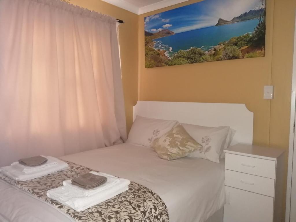 ein Schlafzimmer mit einem Bett mit zwei Handtüchern darauf in der Unterkunft Onyx on Sycamore in Kapstadt