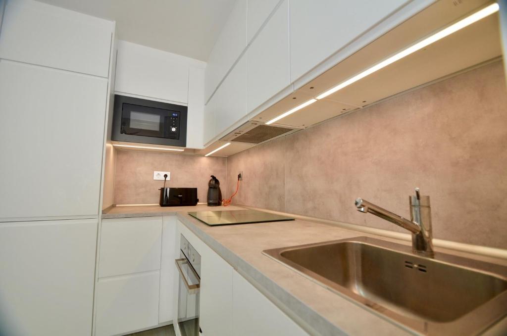 a kitchen with a sink and a microwave at 52 Luxury Pool - AC/WIFI in La Mata