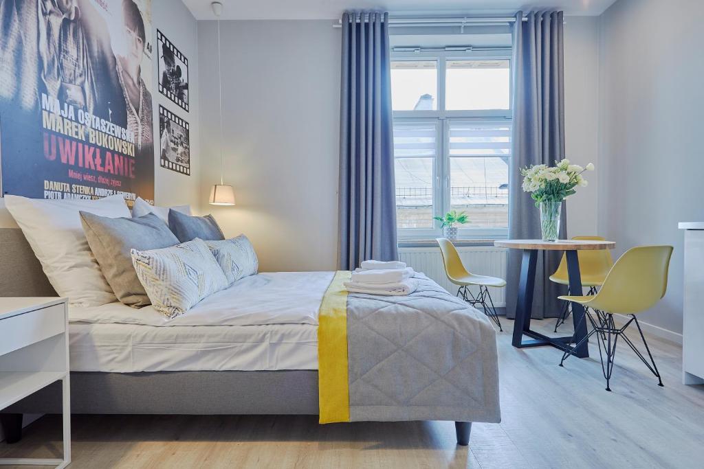 sypialnia z łóżkiem, stołem i krzesłami w obiekcie FLORIANSKA 32 by PI Apartments w Krakowie