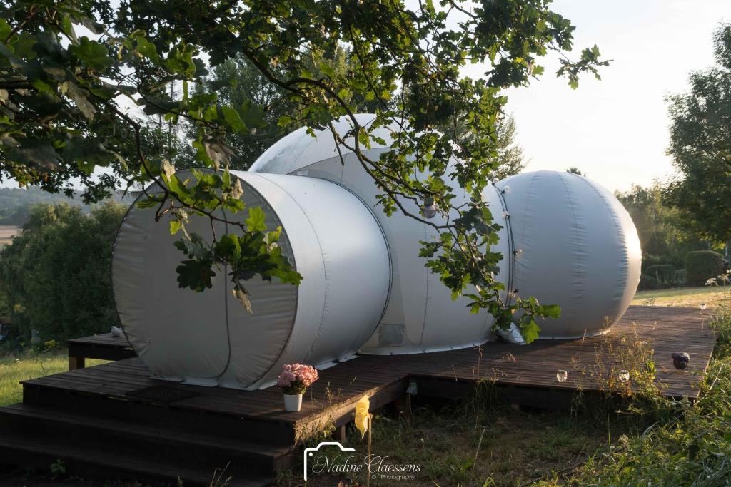 dos cúpulas blancas están sentadas en una terraza de madera en Sleep in a bubble en Wanze