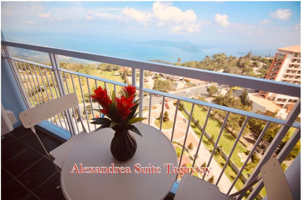 大雅台的住宿－Alexandrea Suite Taal View by Wind SMDC Tagaytay，花瓶坐在阳台上的桌子上