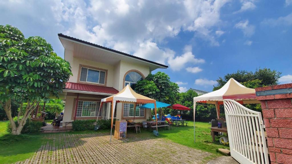 ein Haus mit zwei Sonnenschirmen im Hof in der Unterkunft Emerald Grange in Gongguan